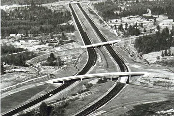 An aerial view of the new I-5 curving through forest and fresh clearings near Swamp Creek, 1967.
