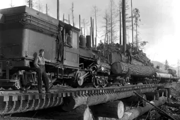 A logging locomotive on a timber bridge, hauling a load of huge logs, about 1913.