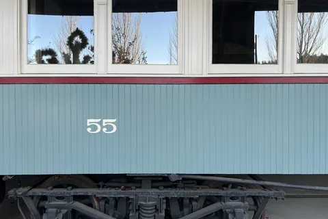 The side of Interurban Car No. 55 in Heritage Park: pale green panels, the number 55 and arched windows.